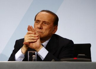 Berlusconi usa a un bebé para calzar una mesa