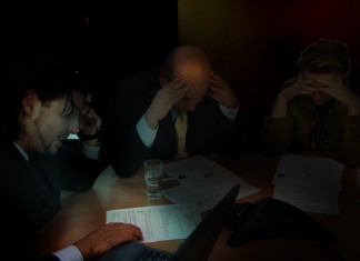 Unos ejecutivos aprovechan la luz de un proyector para contar historias de miedo financiero