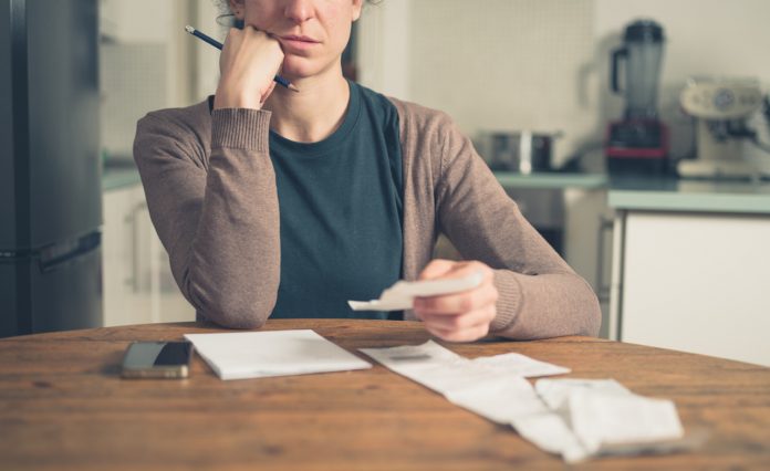 Woman looking at receipts at home