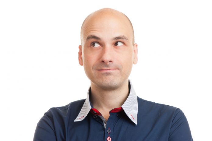 Thinking bald man looking up at copyspace