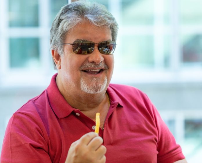 Man portrait eating out some french fries.