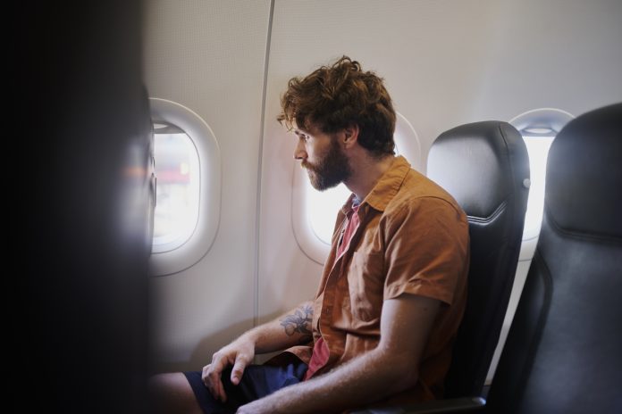 Man, plane window and thinking on travel with reflection, perspective and profile with career decision. Person, digital nomad and flight on airplane, insight and transport for international trip