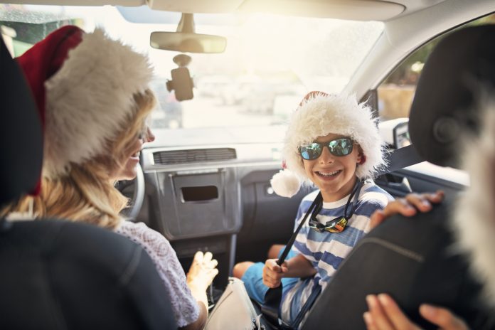 Happy family travelling to beach on Summer Christmas